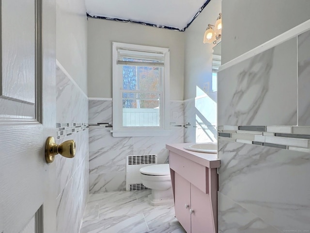 bathroom with radiator heating unit, vanity, tile walls, and toilet