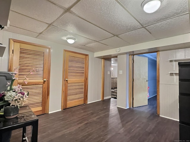 interior space featuring a drop ceiling and dark wood-type flooring