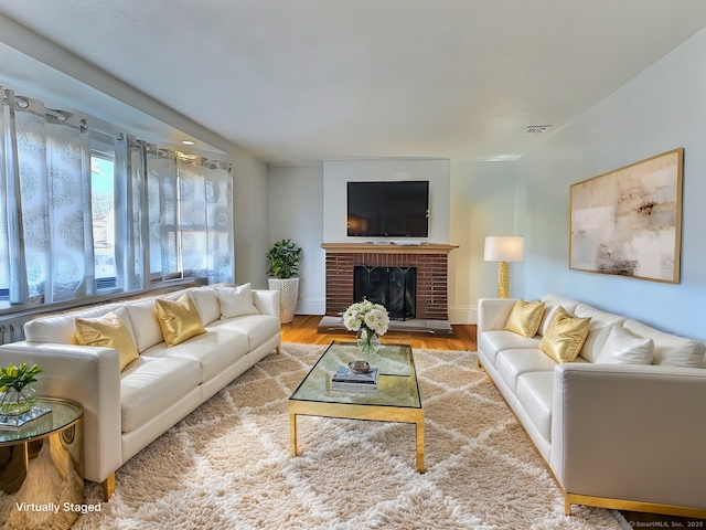 living room with a fireplace and light wood-type flooring