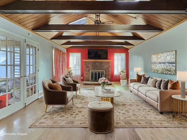 living room with hardwood / wood-style floors, french doors, lofted ceiling with beams, a brick fireplace, and ceiling fan