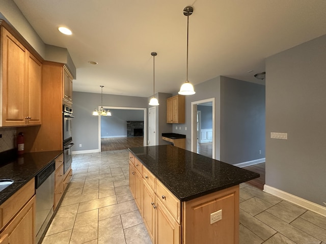 kitchen featuring a center island, stainless steel appliances, hanging light fixtures, and dark stone countertops