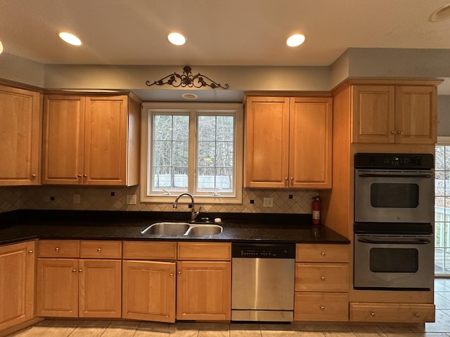 kitchen featuring dark stone counters, sink, decorative backsplash, light tile patterned floors, and appliances with stainless steel finishes