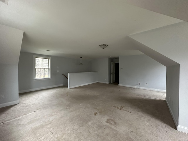 bonus room with light colored carpet and lofted ceiling