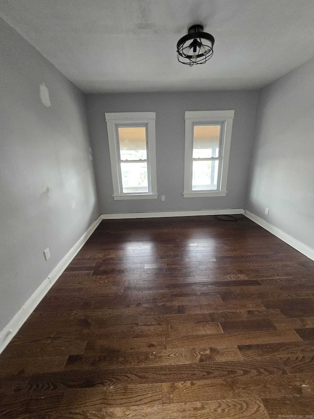 spare room with dark wood-type flooring