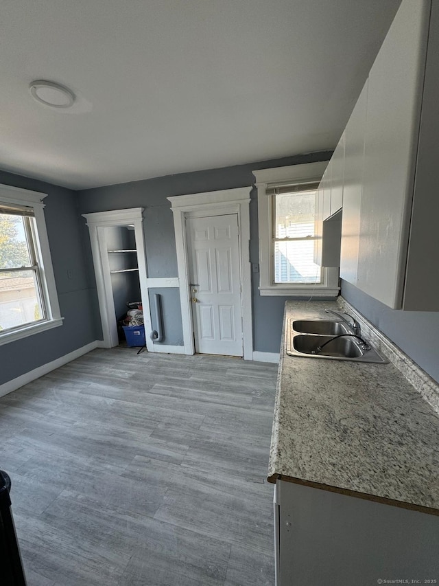 kitchen with white cabinetry, sink, a wealth of natural light, and light hardwood / wood-style flooring