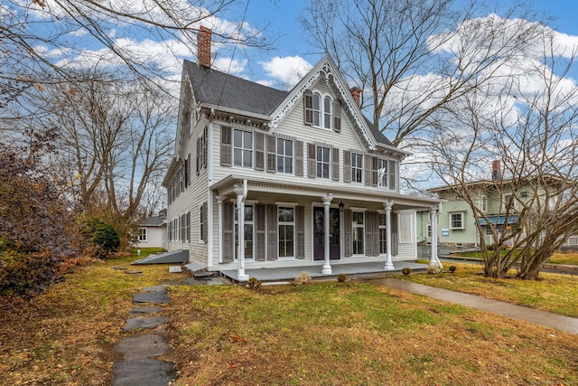 view of front of property with a porch and a front lawn