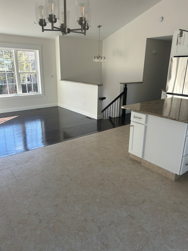 interior space with hardwood / wood-style floors, vaulted ceiling, and an inviting chandelier