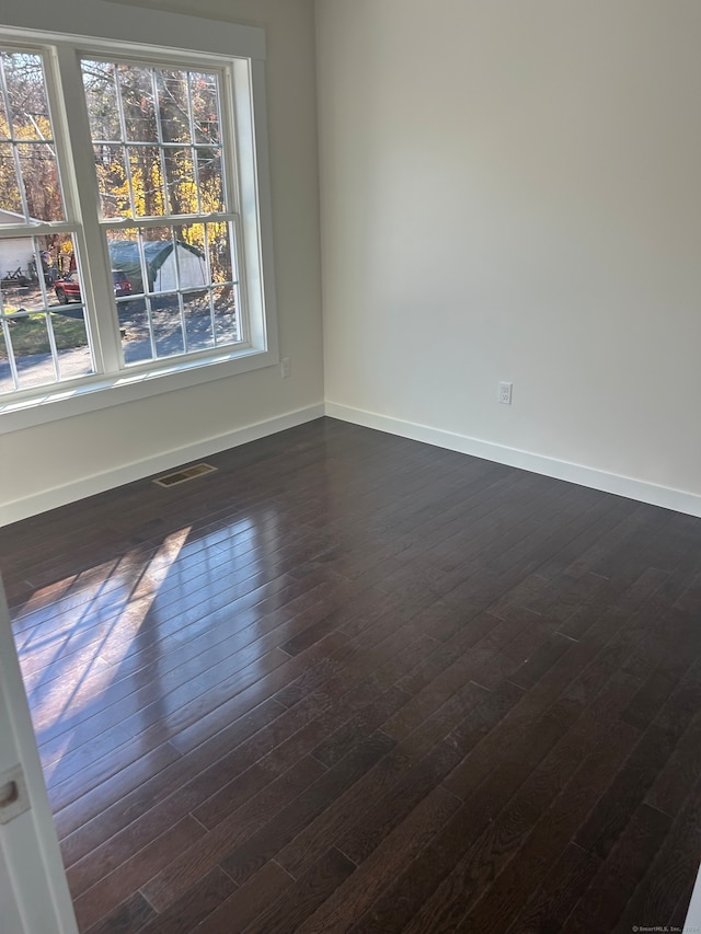 spare room with dark wood-type flooring