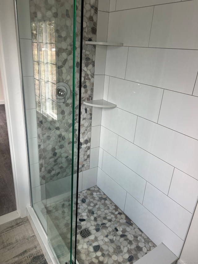 bathroom featuring a shower with shower door