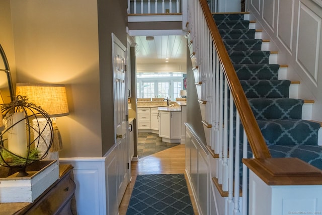 staircase featuring hardwood / wood-style flooring and sink