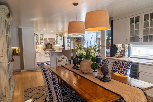 dining room with light hardwood / wood-style flooring and beverage cooler