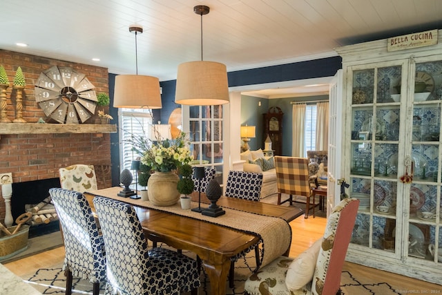 dining area with light hardwood / wood-style floors, a wealth of natural light, and wood ceiling