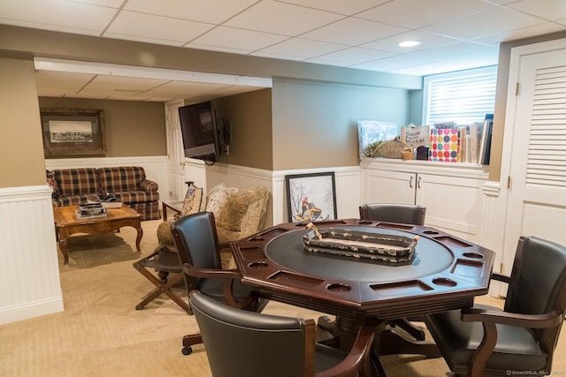 recreation room featuring a paneled ceiling and light carpet