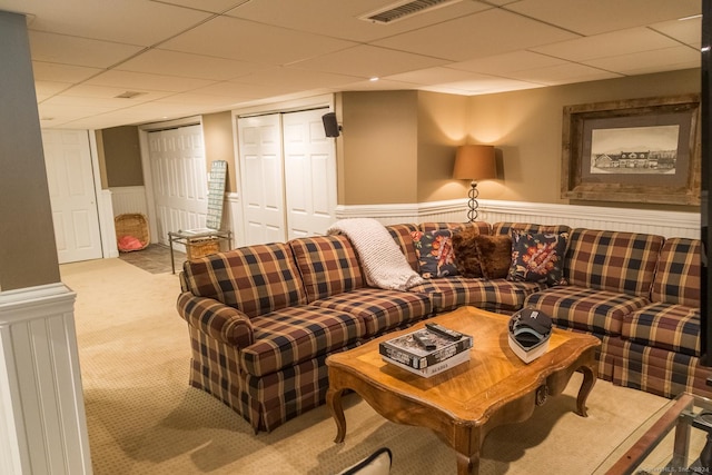 carpeted living room with a drop ceiling