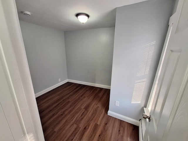 empty room with dark hardwood / wood-style flooring