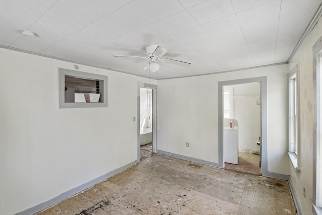 empty room featuring ceiling fan and washer / dryer