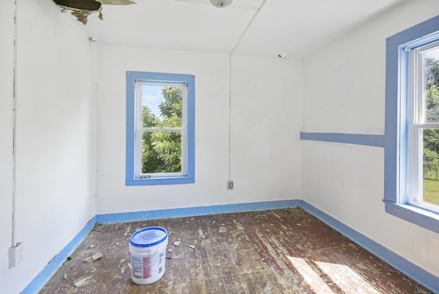 spare room with dark hardwood / wood-style flooring and plenty of natural light