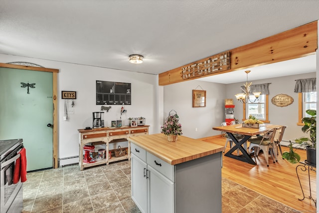 kitchen with wooden counters, pendant lighting, an inviting chandelier, light hardwood / wood-style flooring, and stainless steel electric range oven