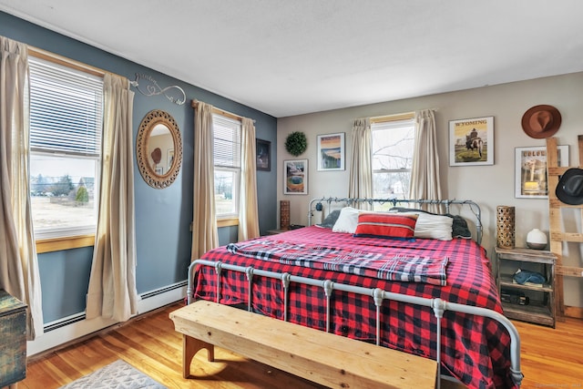 bedroom featuring hardwood / wood-style floors and a baseboard radiator