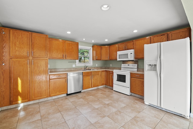 kitchen featuring white appliances, sink, and light tile patterned floors