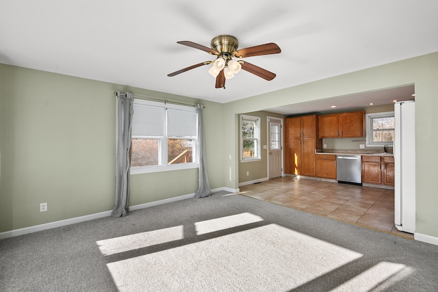 unfurnished living room with light colored carpet and ceiling fan