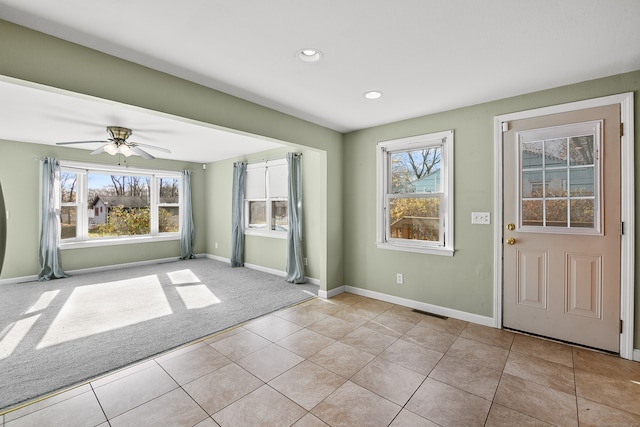 interior space with light tile patterned floors and ceiling fan