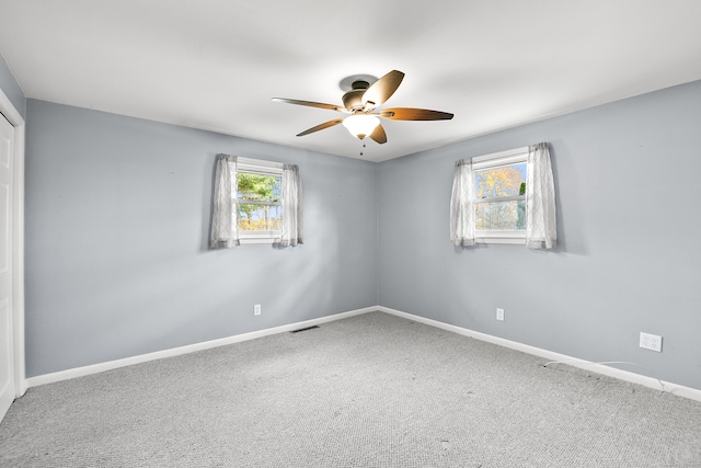 carpeted empty room featuring ceiling fan