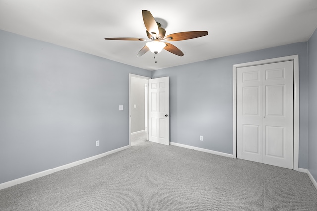 unfurnished bedroom featuring ceiling fan, a closet, and light colored carpet