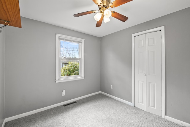 unfurnished bedroom featuring carpet floors, a closet, and ceiling fan