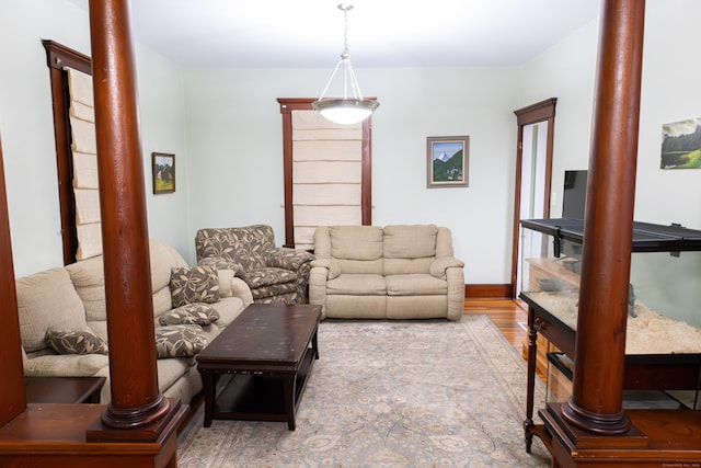 living room featuring wood-type flooring and ornate columns