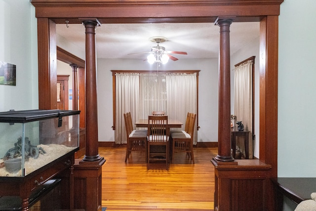 dining area featuring decorative columns, ceiling fan, and light hardwood / wood-style floors