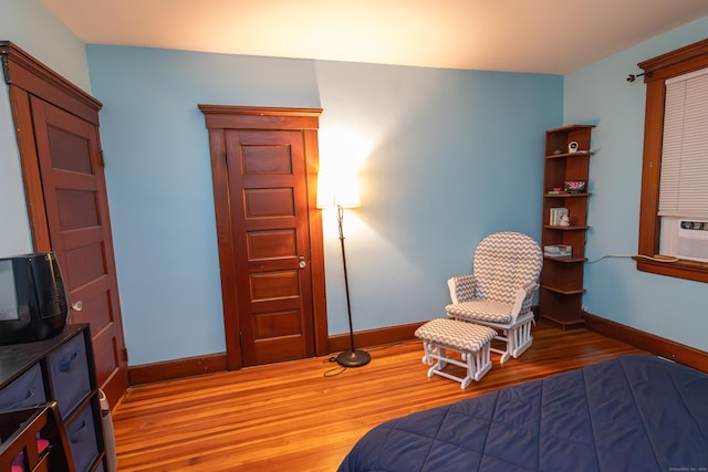 bedroom with cooling unit and hardwood / wood-style flooring