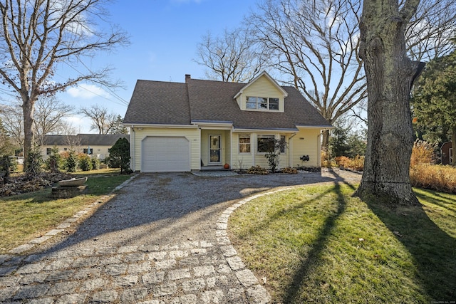 view of front of house with driveway, roof with shingles, a front yard, a garage, and a chimney