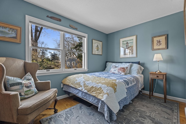 bedroom with dark hardwood / wood-style flooring and a textured ceiling