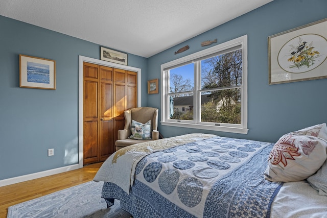 bedroom featuring a closet, wood-type flooring, and a textured ceiling