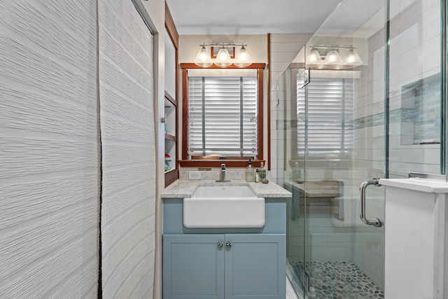 bathroom with vanity and a shower with door