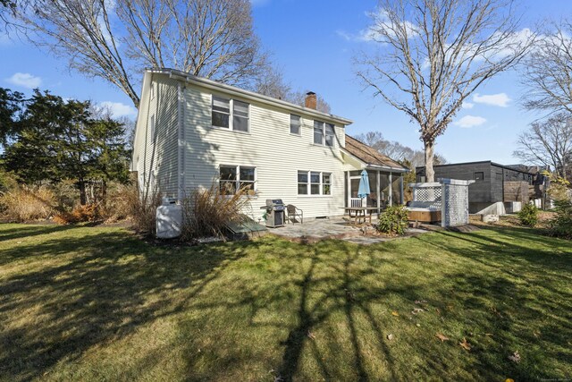 rear view of house with a patio and a lawn