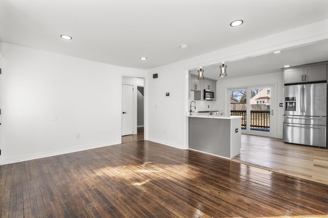 unfurnished living room with sink and dark wood-type flooring