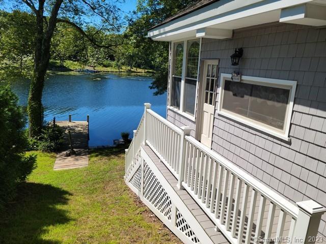 dock area featuring a lawn and a water view