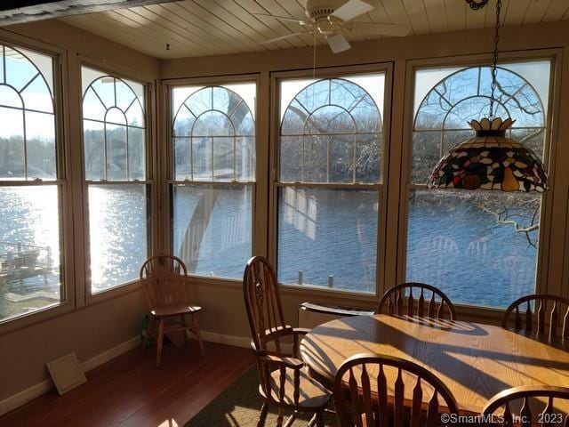 sunroom / solarium featuring wooden ceiling, ceiling fan, and a healthy amount of sunlight