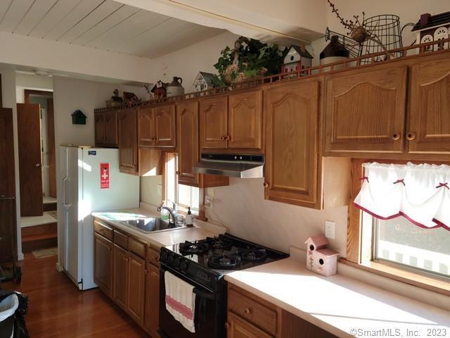 kitchen featuring black range with gas stovetop, sink, a healthy amount of sunlight, and dark hardwood / wood-style flooring