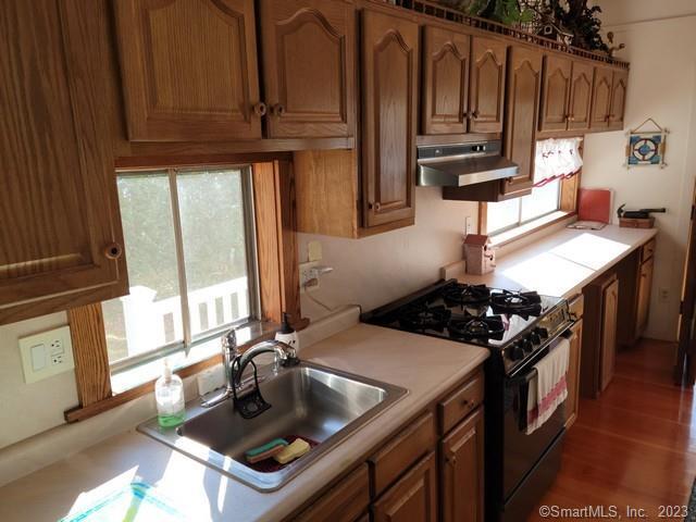 kitchen featuring high end range, dark hardwood / wood-style floors, and sink