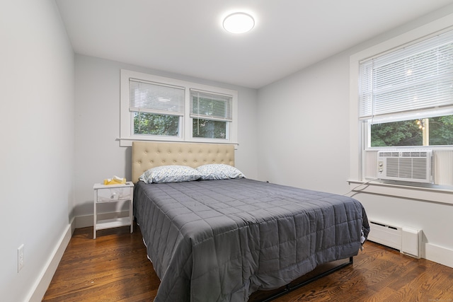 bedroom featuring baseboard heating and dark wood-type flooring