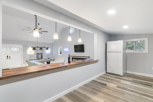 kitchen featuring wood counters, vaulted ceiling, light hardwood / wood-style flooring, white fridge, and pool table