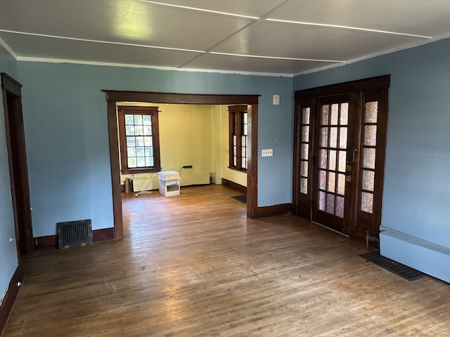 empty room with hardwood / wood-style floors and ornamental molding