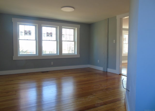 spare room featuring baseboards, visible vents, and dark wood-style flooring