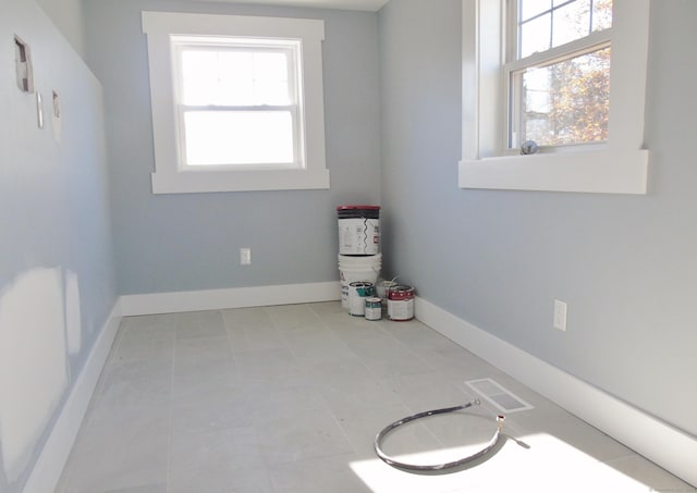 empty room featuring tile patterned floors, baseboards, and visible vents