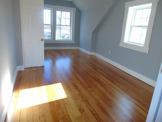 bonus room featuring baseboards, lofted ceiling, and hardwood / wood-style flooring
