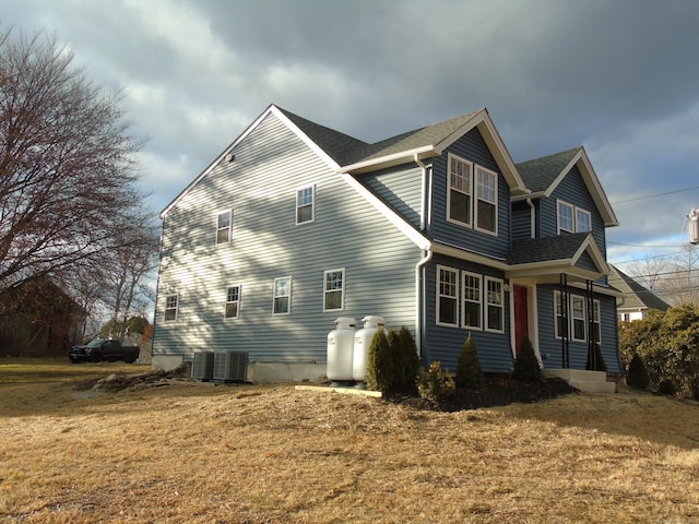 view of home's exterior with a lawn and central AC