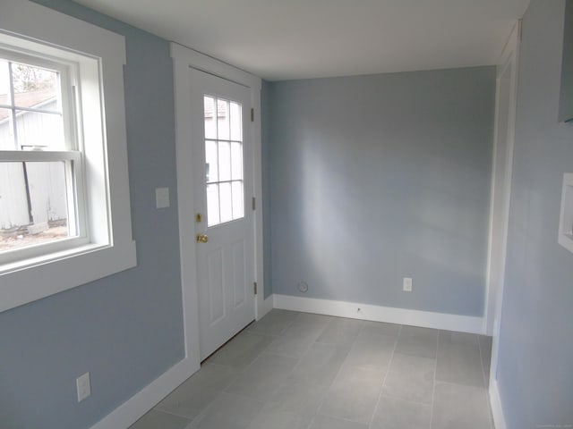 doorway featuring a healthy amount of sunlight and light tile patterned floors